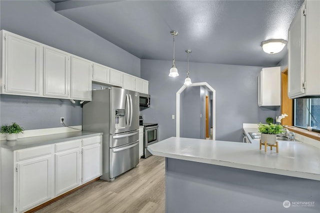 kitchen with kitchen peninsula, appliances with stainless steel finishes, and white cabinetry