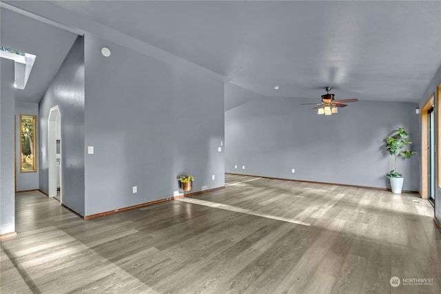 unfurnished living room featuring ceiling fan, vaulted ceiling, and light wood-type flooring