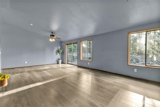 spare room featuring light hardwood / wood-style flooring, a wealth of natural light, and ceiling fan