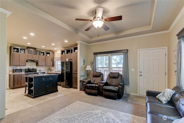 carpeted living room featuring ceiling fan, ornamental molding, and a raised ceiling