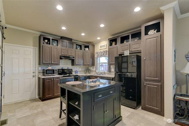 kitchen featuring black appliances, a center island, ornamental molding, decorative backsplash, and dark brown cabinets