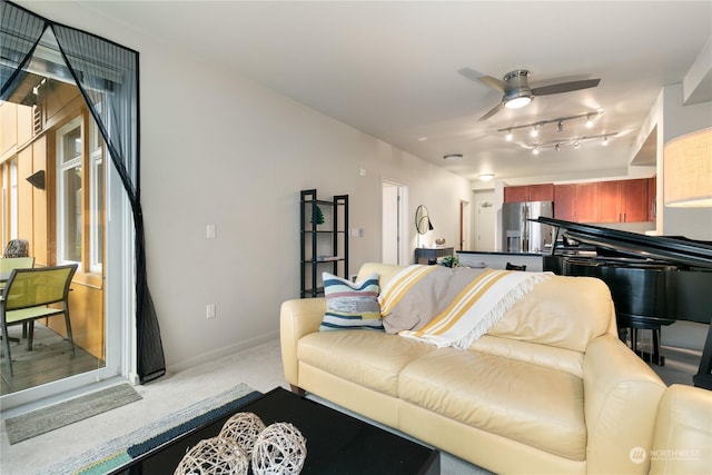 living room featuring light carpet, rail lighting, and ceiling fan