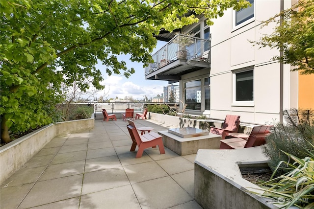 view of patio / terrace with a balcony and an outdoor fire pit