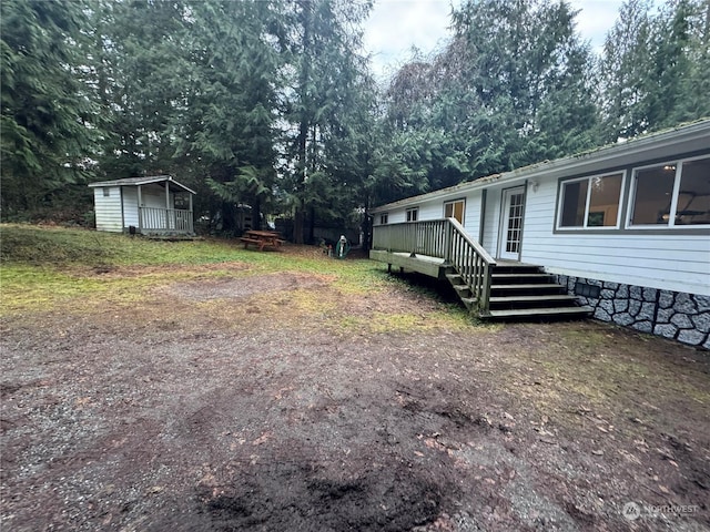 view of yard with a deck and a storage unit