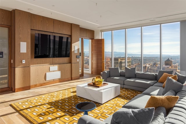 living room featuring wood-type flooring, floor to ceiling windows, and wood walls