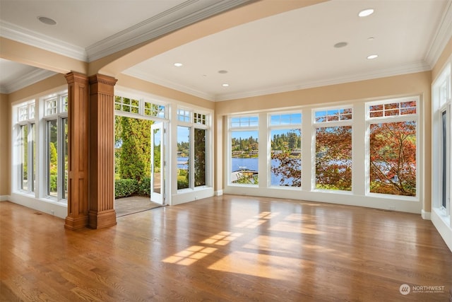 unfurnished sunroom with decorative columns and a water view