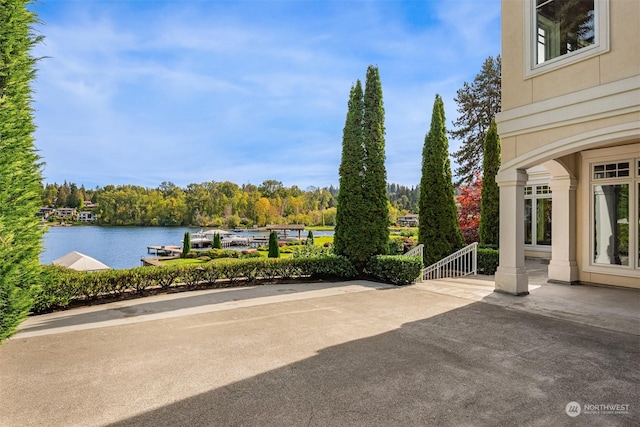 view of patio featuring a water view and a dock