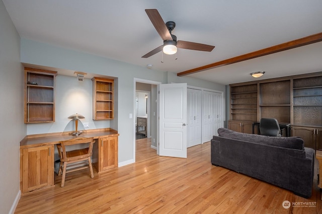 living room featuring beamed ceiling, light hardwood / wood-style flooring, and ceiling fan