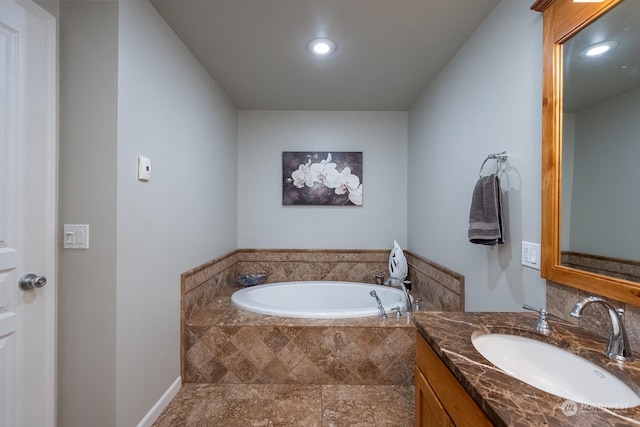 bathroom with vanity and a relaxing tiled tub