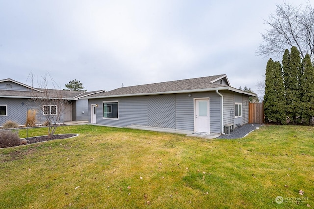 back of property featuring a lawn and central air condition unit