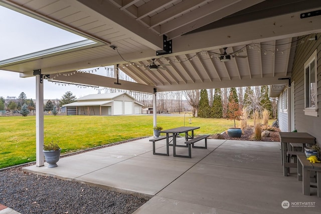 view of patio / terrace with ceiling fan, an outbuilding, and a garage