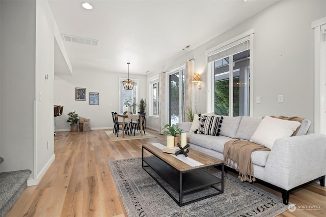 living room featuring an inviting chandelier and light hardwood / wood-style flooring