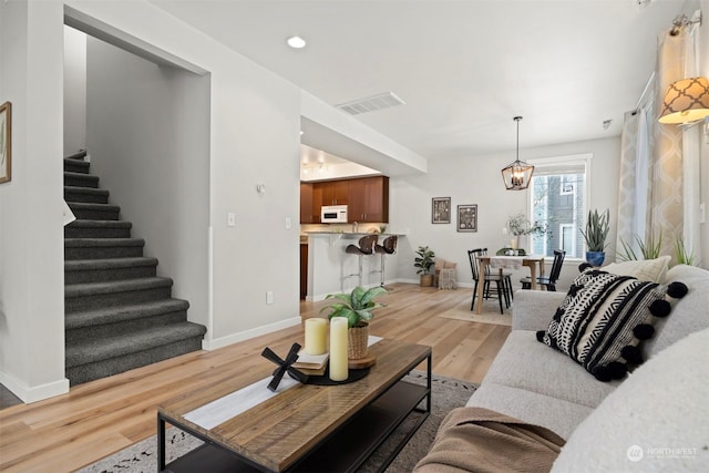 living room with light hardwood / wood-style flooring and a chandelier