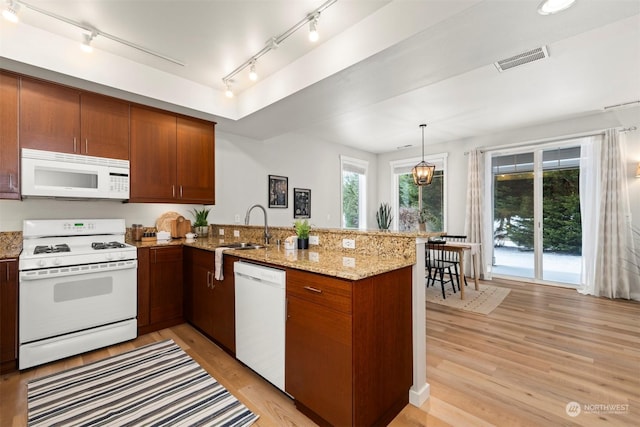 kitchen featuring sink, white appliances, decorative light fixtures, kitchen peninsula, and light wood-type flooring