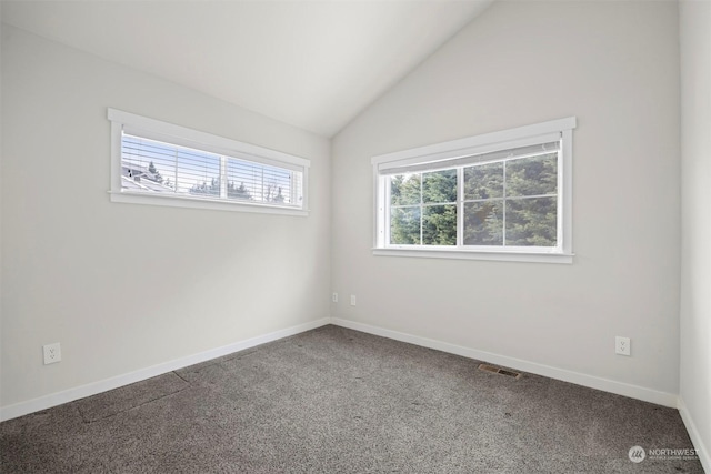 carpeted spare room with vaulted ceiling