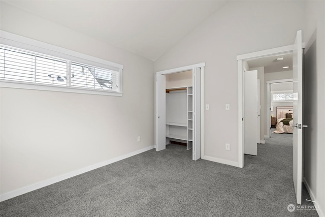 unfurnished bedroom featuring lofted ceiling and dark carpet