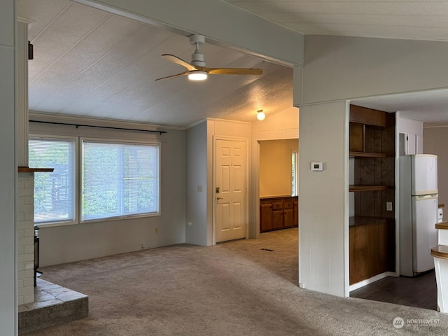 unfurnished living room featuring a fireplace, carpet floors, vaulted ceiling, and ceiling fan