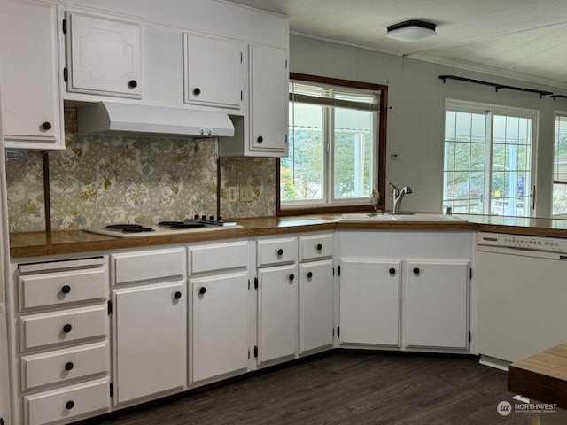 kitchen with white appliances, white cabinetry, a wealth of natural light, and sink