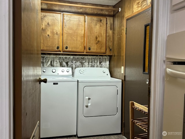 washroom featuring washing machine and dryer and cabinets