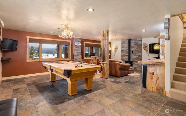 game room with an inviting chandelier, pool table, and a wood stove