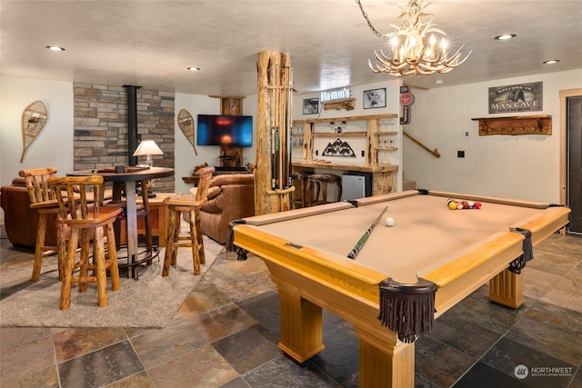 rec room with an inviting chandelier, billiards, and a wood stove