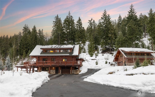 log-style house featuring a garage and a deck