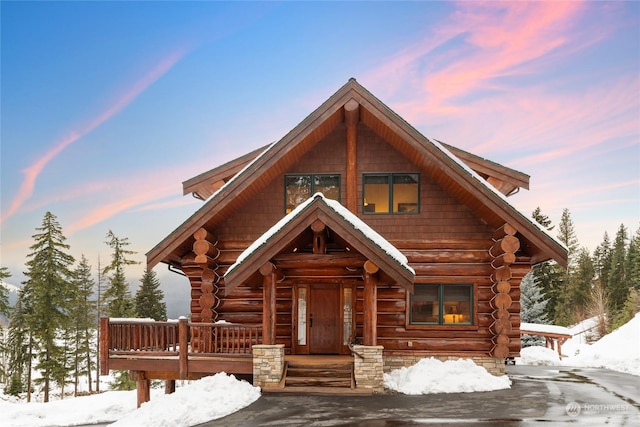 log home featuring covered porch