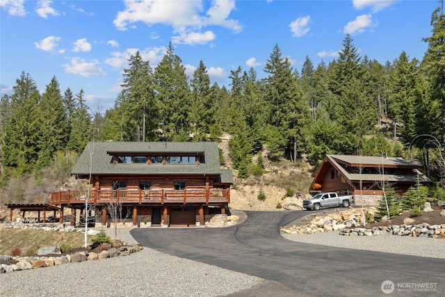 71 Morgan Creek Rd, Ronald, WA 98940 - log home with a garage, log siding, a deck, a view of trees, and driveway