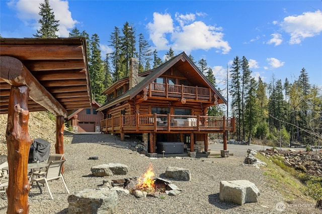 71 Morgan Creek Rd, Ronald, WA 98940 - rear view of house with a fire pit, a chimney, a wooden deck, a hot tub, and log exterior