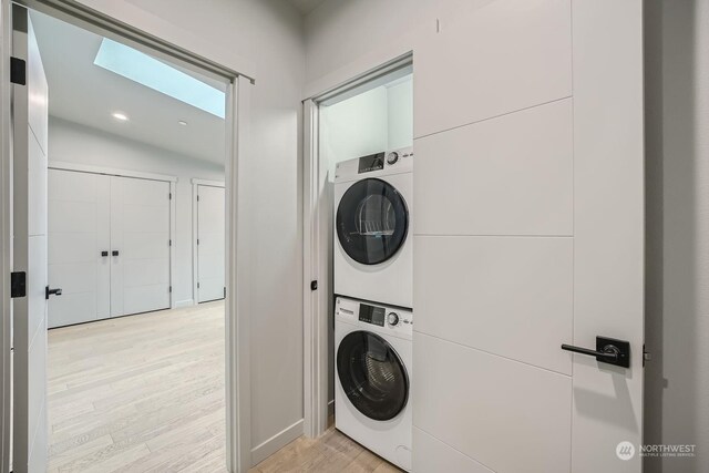 washroom featuring stacked washing maching and dryer and light wood-type flooring