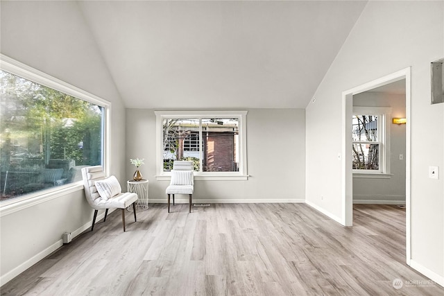 sitting room featuring light wood-type flooring and vaulted ceiling