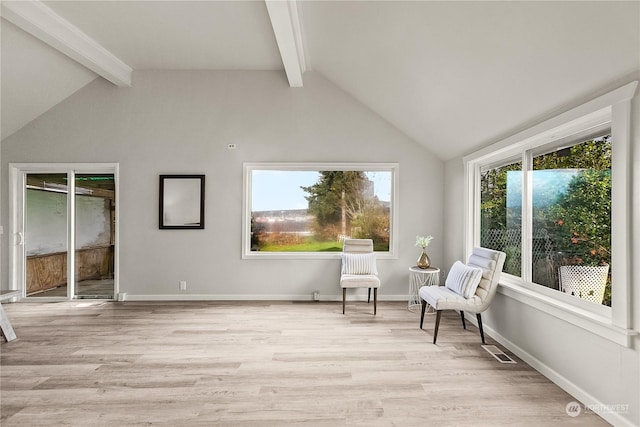 living area with light hardwood / wood-style floors and vaulted ceiling with beams