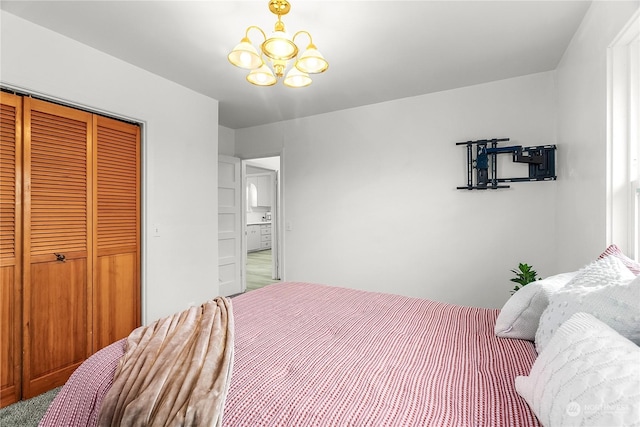 bedroom with a closet, a chandelier, and carpet flooring