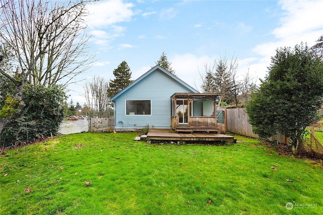 rear view of property with a deck and a lawn