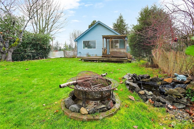 view of yard with an outdoor fire pit and a wooden deck