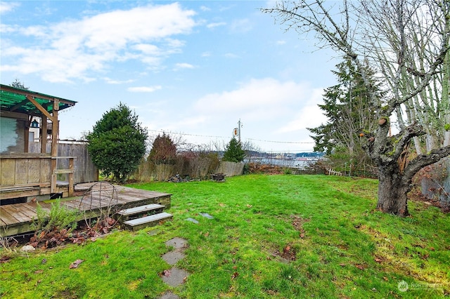 view of yard with a deck with water view