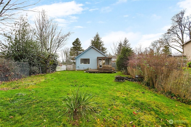 view of yard with a wooden deck and a fire pit