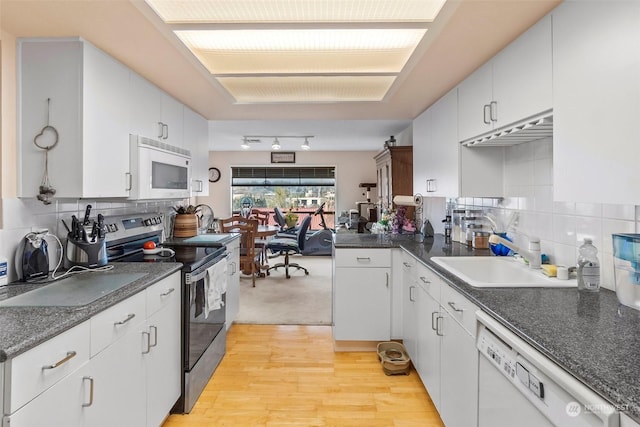 kitchen with white cabinetry, white appliances, and sink