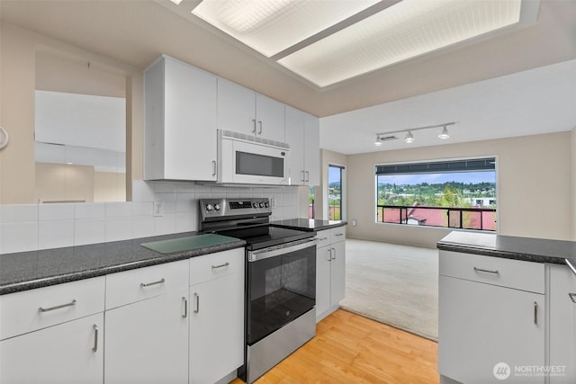 908 E Bay Dr NE Unit 203, Olympia, WA 98506 - kitchen featuring white microwave, stainless steel range with electric stovetop, dark countertops, light wood-type flooring, and white cabinets
