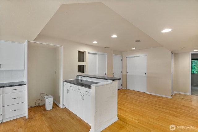 908 E Bay Dr NE Unit 203, Olympia, WA 98506 - kitchen with white cabinets, a peninsula, light wood-style floors, dark countertops, and recessed lighting