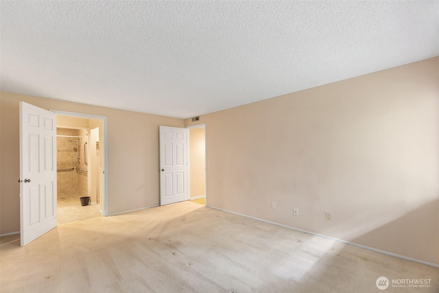 908 E Bay Dr NE Unit 203, Olympia, WA 98506 - empty room with light colored carpet, a textured ceiling, and baseboards