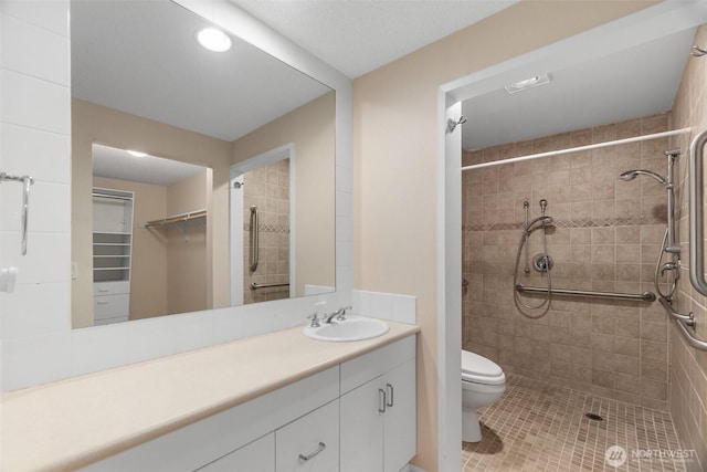 908 E Bay Dr NE Unit 203, Olympia, WA 98506 - bathroom featuring a shower stall, tile patterned floors, vanity, toilet, and a walk in closet