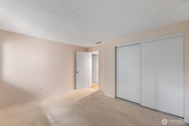 908 E Bay Dr NE Unit 203, Olympia, WA 98506 - unfurnished bedroom with carpet flooring, a closet, and a textured ceiling