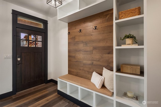 mudroom with dark hardwood / wood-style floors and wooden walls