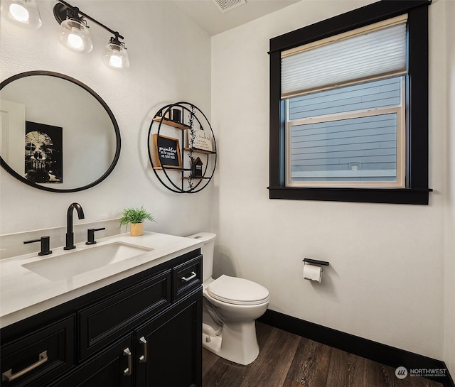 bathroom featuring toilet, vanity, and hardwood / wood-style flooring