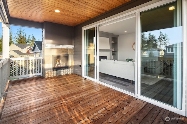 wooden terrace featuring a tiled fireplace