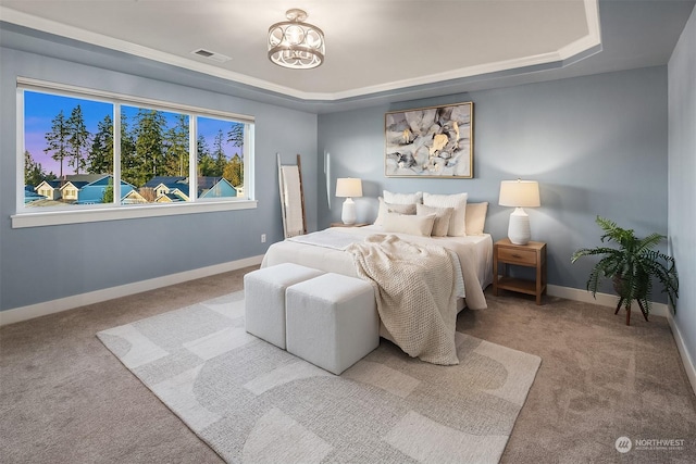 bedroom with a notable chandelier, light colored carpet, and a tray ceiling