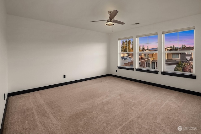 spare room featuring light colored carpet and ceiling fan