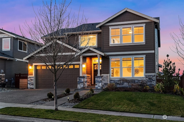 craftsman inspired home with a garage and a yard