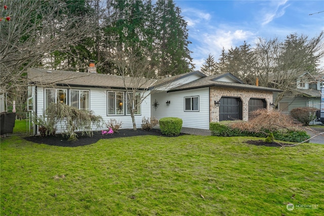 rear view of house with a yard and a garage